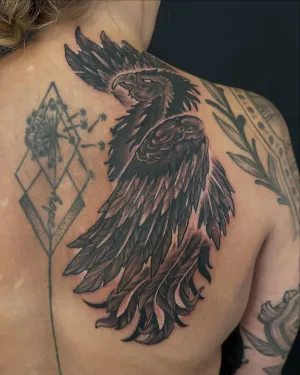 Black and grey raven with fine geometric linework across a shoulder blade — by Adam Crane