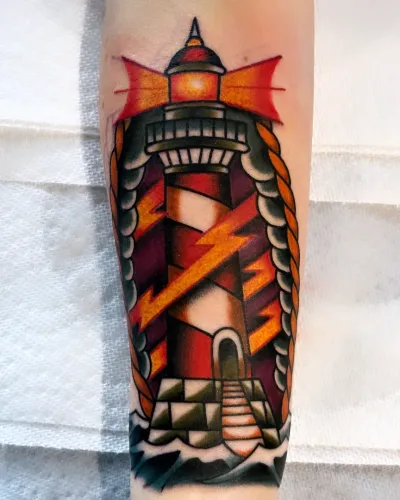 Colour American traditional lighthouse with red beams on a forearm — by Chay Menke at Ministry Ink