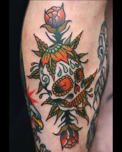 Colour sugar skull with roses on an upper arm — by Chay Menke at Ministry Ink