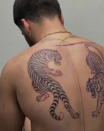 Black and grey tiger prowling across an upper back — by Gabriel Gonzalez at Ministry Ink