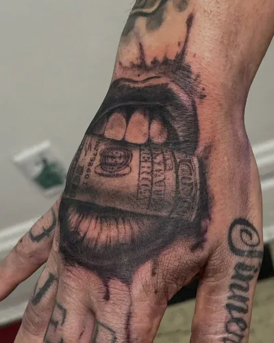Black and grey money-mouth portrait tattooed on a hand — by Gabriel Gonzalez at Ministry Ink